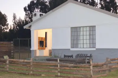 a white house with a fence in front of it at Dullstroom on the Dam in Dullstroom