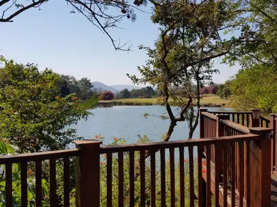 a view of a lake from a wooden fence at Kruger Park Lodge ITR01 3 Bedroom in Hazyview