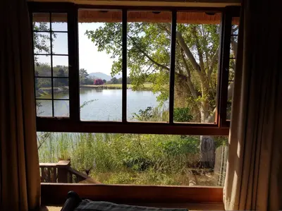 a window with a view of a lake seen through it at Kruger Park Lodge ITR01 3 Bedroom in Hazyview