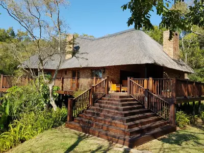 a home with a staircase leading to a thatch roof at Kruger Park Lodge ITR01 3 Bedroom in Hazyview