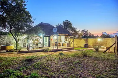 a small house with a thatched roof at LookOut Safari Lodge in Klipdrift