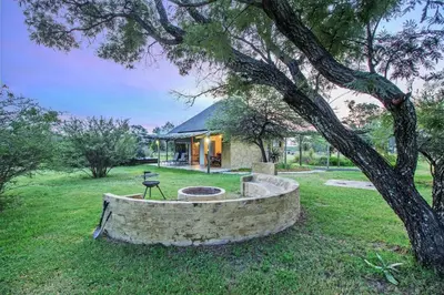 a house with a tree and a fire pit at LookOut Safari Lodge in Klipdrift