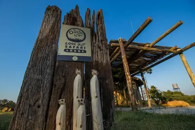 a sign on a wooden pole with surfboards on it at LookOut Safari Lodge in Klipdrift