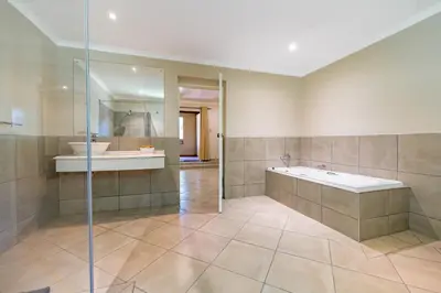a bathroom with a shower and a tub and a sink at Hotel Numbi & Garden Suites in Hazyview