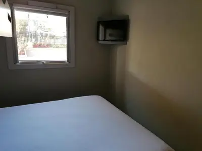 a bed in a room with a window at SUN1 WITBANK in Witbank