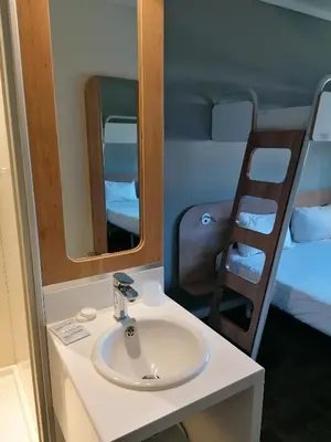 a bathroom with a sink and a mirror and a bed at SUN1 WITBANK in Witbank