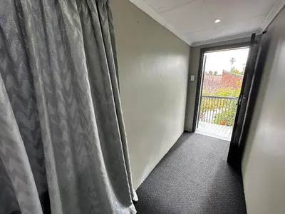 a room with a window with a curtain and a door at Favour Guest house in Polokwane