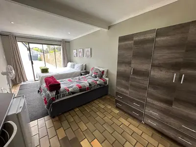 a bedroom with a bed and a large closet at Favour Guest house in Polokwane