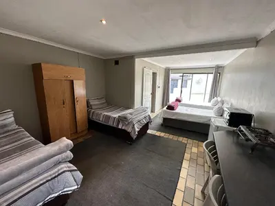 a room with two beds and a window at Favour Guest house in Polokwane