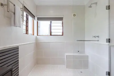 a white bathroom with a tub and a sink at Matumi Golf Lodge in Nelspruit