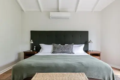 a bedroom with a large bed with a green blanket at Matumi Golf Lodge in Nelspruit