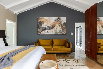 a bedroom with a bed and a couch at Matumi Golf Lodge in Nelspruit