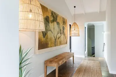 a hallway with a bench and a painting on the wall at Matumi Golf Lodge in Nelspruit