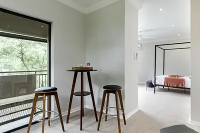 a bedroom with two bar stools and a bed at Matumi Golf Lodge in Nelspruit