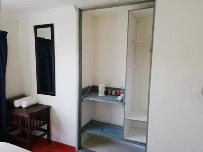 a closet with a mirror and a wooden table at Home @ Harry's in Pretoria