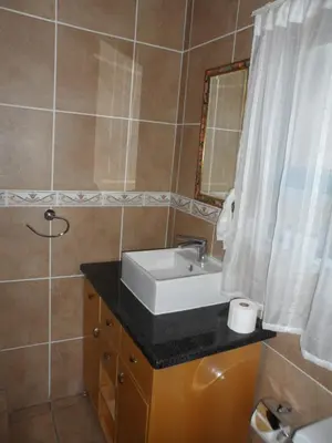 a bathroom with a sink and a mirror at Home @ Harry's in Pretoria