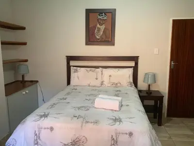a bedroom with a large bed with a bedspread with at At The Rocks Country Estate in Avondzon
