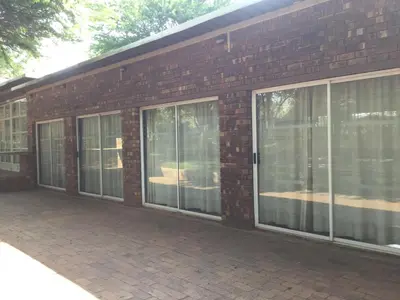 a brick building with sliding glass doors on it at At The Rocks Country Estate in Avondzon