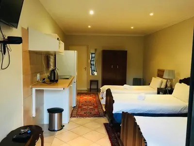 a hotel room with two beds and a kitchen at At The Rocks Country Estate in Avondzon