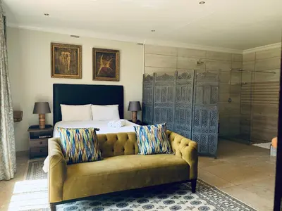 a bedroom with a bed and a couch at At The Rocks Country Estate in Avondzon