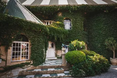 a house covered in ivy with a white door and stairs at Schoon Huis Manor in Kempton Park