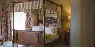 a bedroom with a canopy bed with white pillows at Schoon Huis Manor in Kempton Park