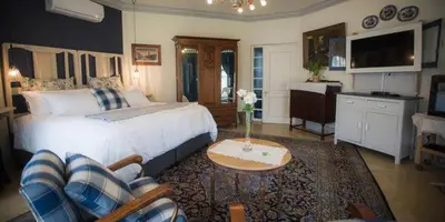 a bedroom with a bed and a table in a room at Schoon Huis Manor in Kempton Park