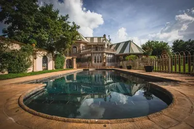 a large house with a swimming pool in front of it at Schoon Huis Manor in Kempton Park