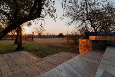a view of a park with a tree and a fence at Cottage Lenise in Phalaborwa