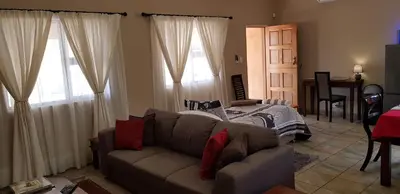 a living room with a couch and a bed at Cottage Lenise in Phalaborwa