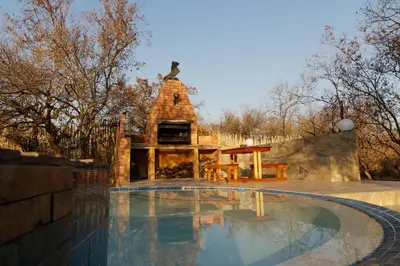 a swimming pool with a gazebo in a yard at Cottage Lenise in Phalaborwa