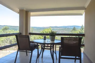 a table and chairs on a balcony with a view at Cuckoo Ridge Country Retreat in Hazyview