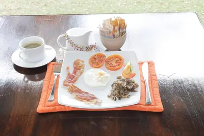 a plate of food on a table with a cup of coffee at Cuckoo Ridge Country Retreat in Hazyview