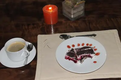 a piece of cake on a plate next to a cup of coffee at Cuckoo Ridge Country Retreat in Hazyview