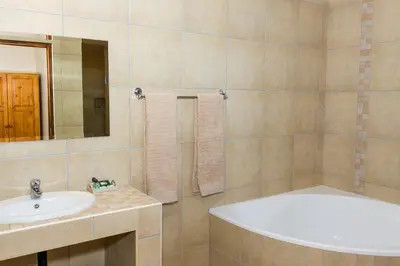 a bathroom with a tub and a sink at Cuckoo Ridge Country Retreat in Hazyview