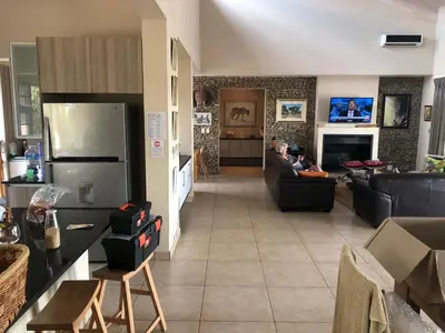 a man sitting on a couch in a living room at Crocodile Bend in Mpakeni