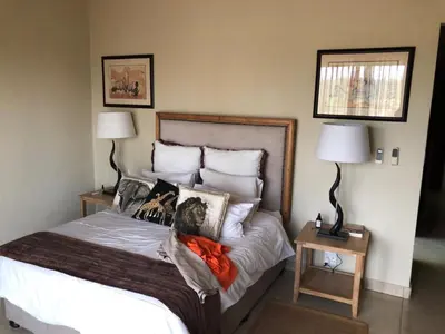a bedroom with a large bed with two lamps at Crocodile Bend in Mpakeni