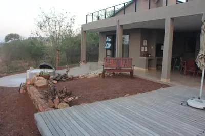 a patio with a bench in front of a house at Crocodile Bend in Mpakeni