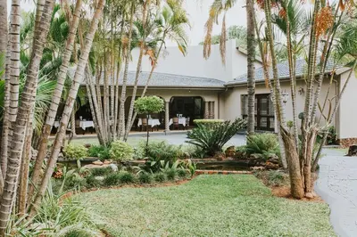 a house with palm trees in the yard at Iso'Bella Vita Guesthouse in Phalaborwa