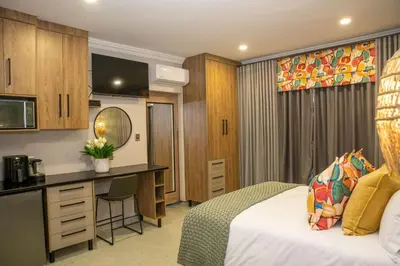a hotel room with a bed and a desk at Iso'Bella Vita Guesthouse in Phalaborwa