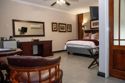 a room with a bedroom with a bed and a mirror at Iso'Bella Vita Guesthouse in Phalaborwa
