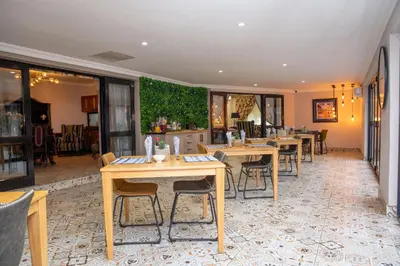 a restaurant with tables and chairs in a room at Iso'Bella Vita Guesthouse in Phalaborwa