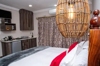 a bedroom with a bed and a chandelier at Iso'Bella Vita Guesthouse in Phalaborwa