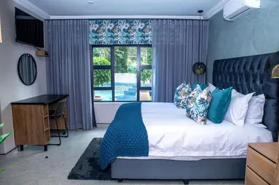 a bedroom with a large bed and a window at Iso'Bella Vita Guesthouse in Phalaborwa