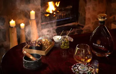 a table with a bottle of wine and a glass at Pondoro Game Lodge in Balule Game Reserve