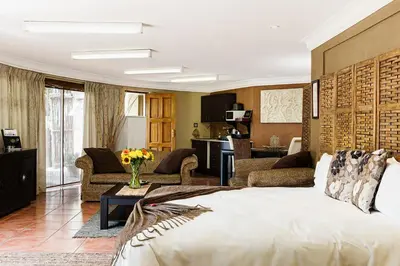 a living room with a large bed and a living room at Glenda's Guest Suites in Midrand