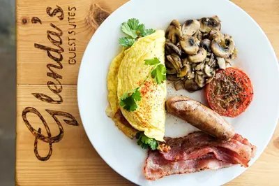 a plate of breakfast food with eggs sausage and mushrooms at Glenda's Guest Suites in Midrand