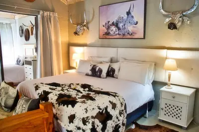 a bedroom with a black and white bed with antlers on the wall at Glenda's Guest Suites in Midrand