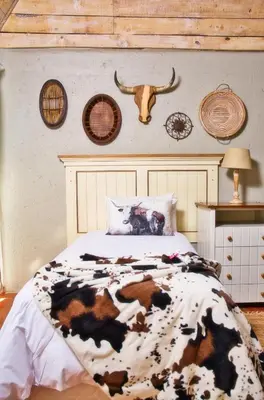 a bedroom with a cow blanket on a bed at Glenda's Guest Suites in Midrand