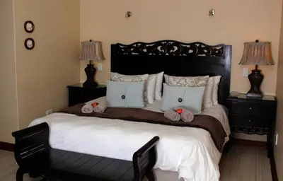 a bedroom with a large bed with towels on it at Del Roza Guest House in Middelburg